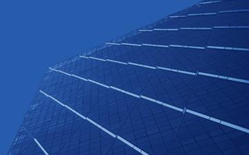 Blue-colored background with reflections off the side of an office building